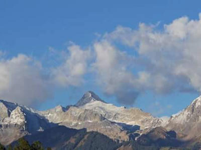 Majestic Snow-capped Peaks Under Blue Skies Vista.jpg